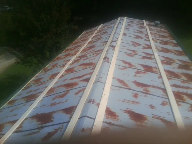 Rusted metal roof panels with new wood purlins before replacement — Storm Damage Roof Repair in Magna by Roofing Brothers